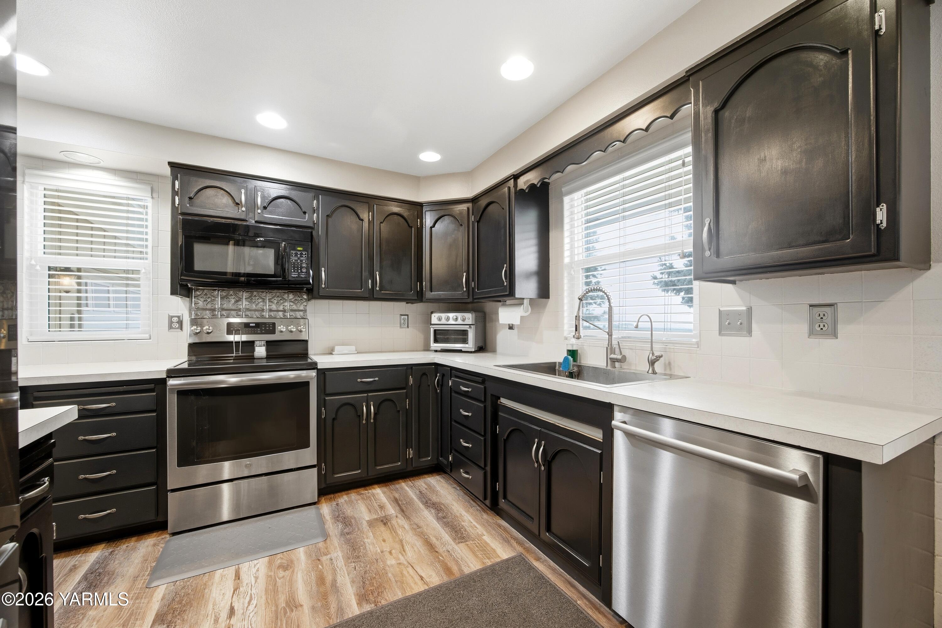 1681 Olmstead Road Grandview, WA 98930 - Photo 41 of 49 a kitchen with stainless steel appliances a stove sink microwave and cabinets