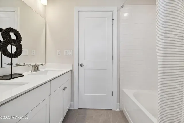 a bathroom with a tub sink and mirror