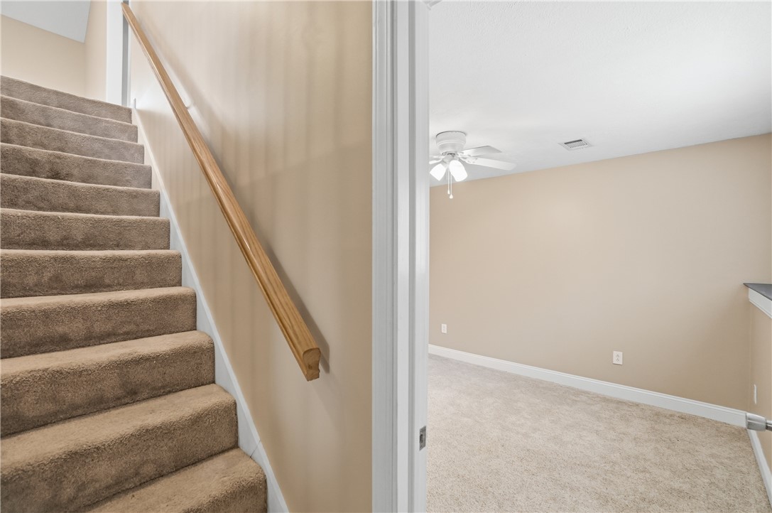 1208 Jarva Lane Springboro, OH 45066 - Photo 47 of 75 This interior captures a carpeted staircase leading to an upstairs room with a ceiling fan.