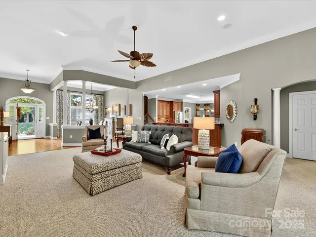 a living room with furniture a ceiling fan a rug and a chandelier