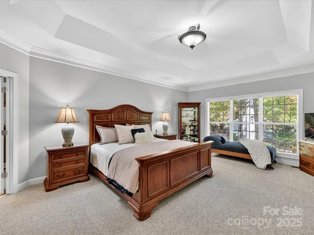 a bedroom with a bed and large windows