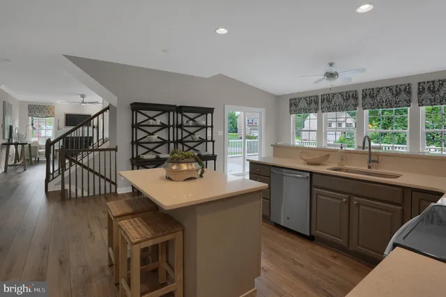 a kitchen with a sink a stove a refrigerator cabinets and a dining table