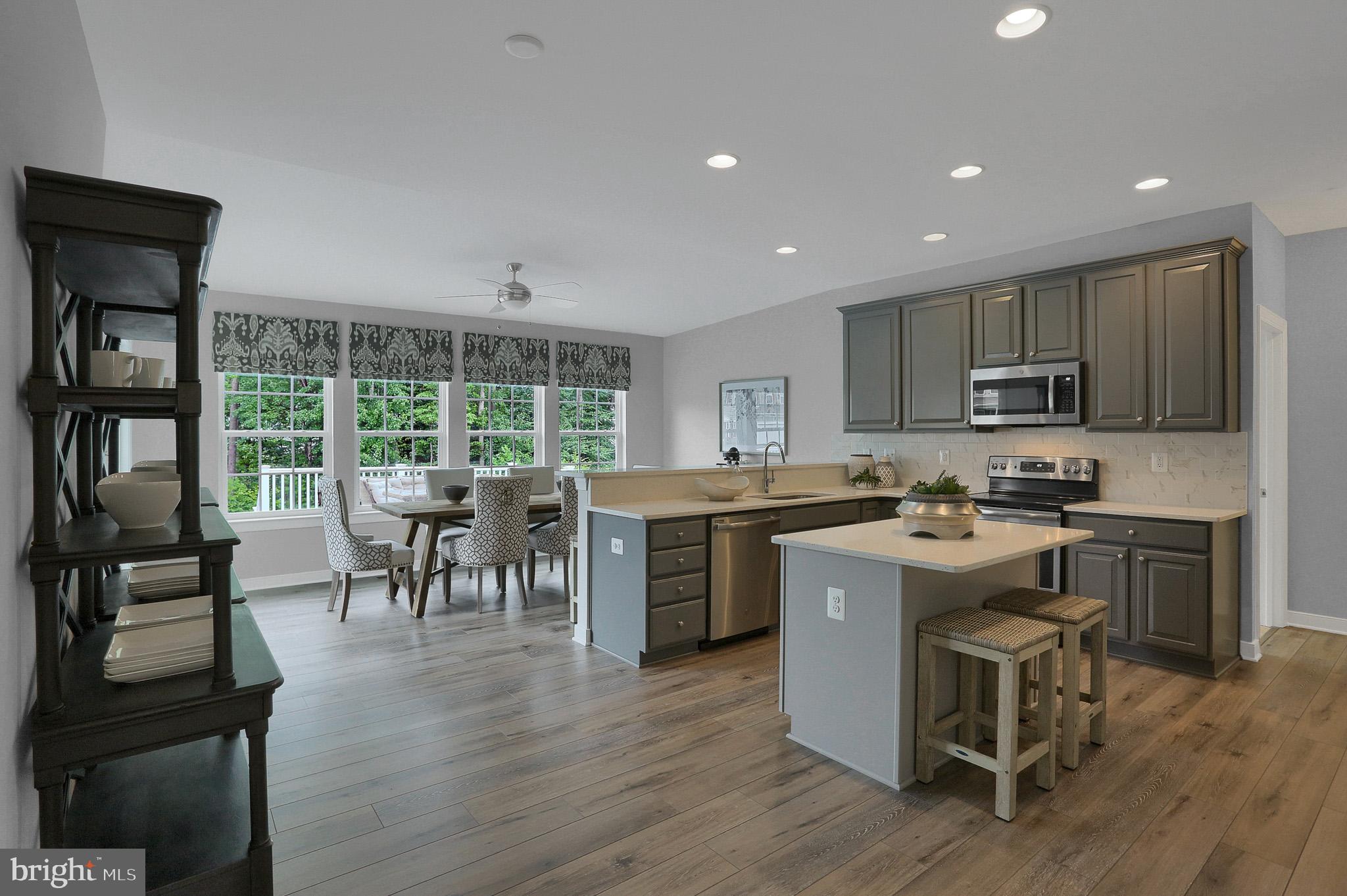 1205 Van Bibber Road Edgewood, MD 21040 - Photo 14 of 17 a kitchen with stainless steel appliances granite countertop a stove top oven a sink a dining table and chairs with wooden floor