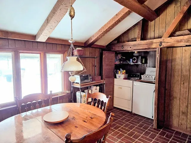 a dining room with furniture a chandelier and window