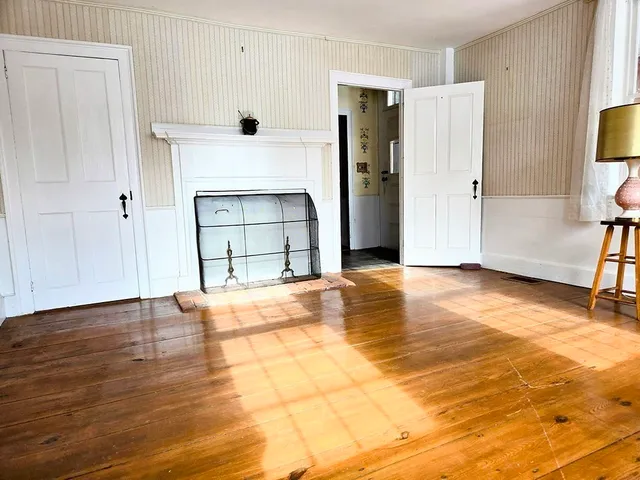 a view of a livingroom with a fireplace and window