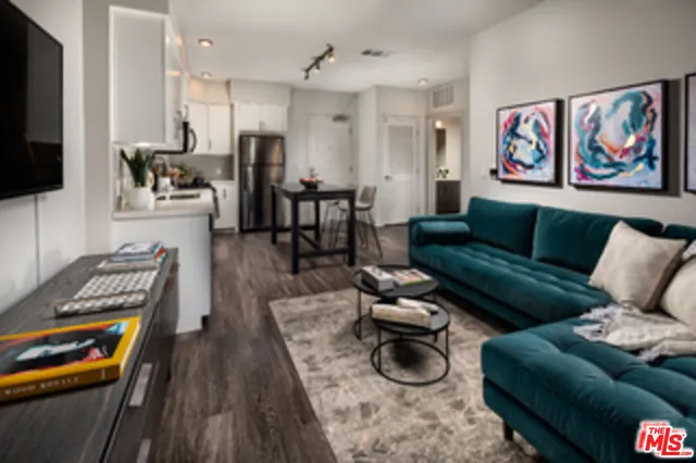 a view of a livingroom and dining room with furniture wooden floor and a rug