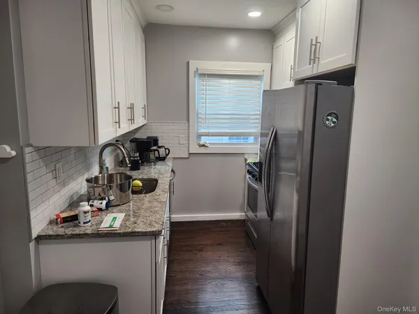 a kitchen with a refrigerator sink and cabinets