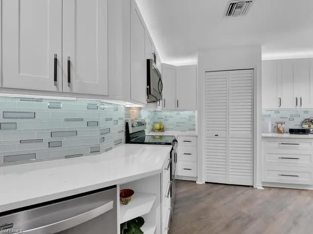 a kitchen with cabinets appliances and a counter space