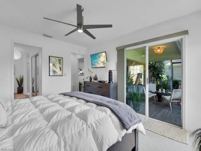 a bedroom with a balcony a bed and a view of living room