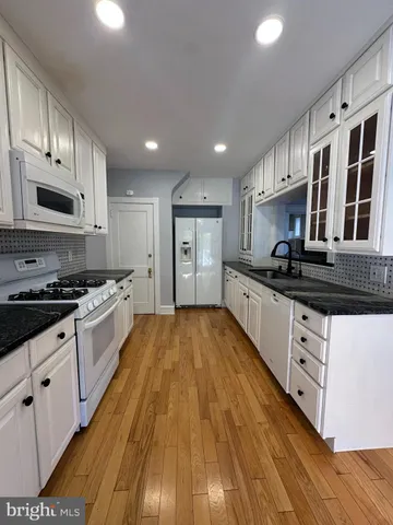 a large kitchen with stainless steel appliances granite countertop a stove and a sink