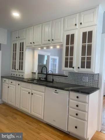 a kitchen with granite countertop white cabinets and sink