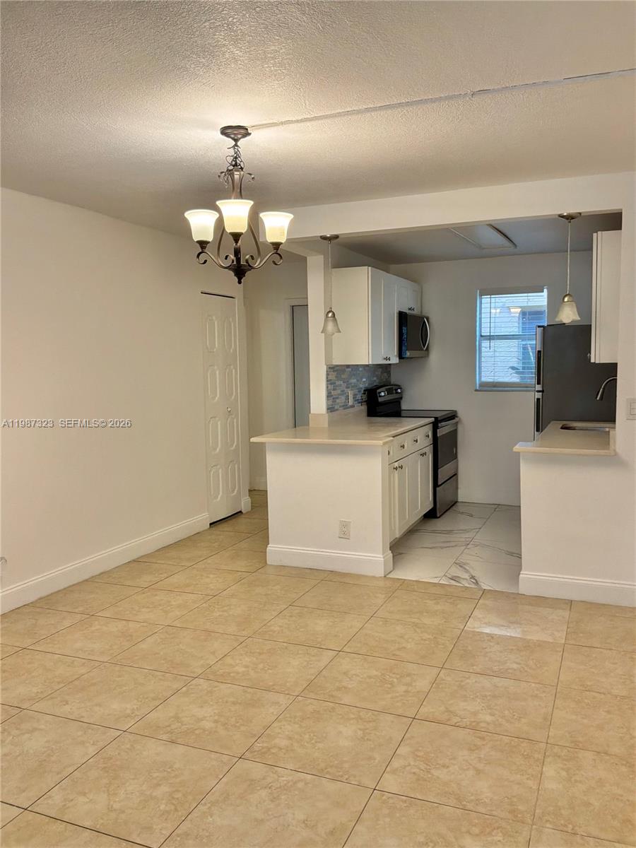 550 Southwest 2nd Avenue, Unit 1210 Boca Raton, FL 33432 - Photo 4 of 18 a kitchen with granite countertop a stove a sink and a refrigerator