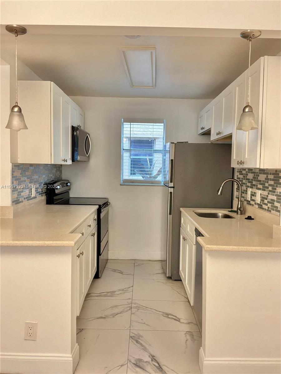 550 Southwest 2nd Avenue, Unit 1210 Boca Raton, FL 33432 - Photo 6 of 18 a kitchen with a stove a refrigerator and a sink