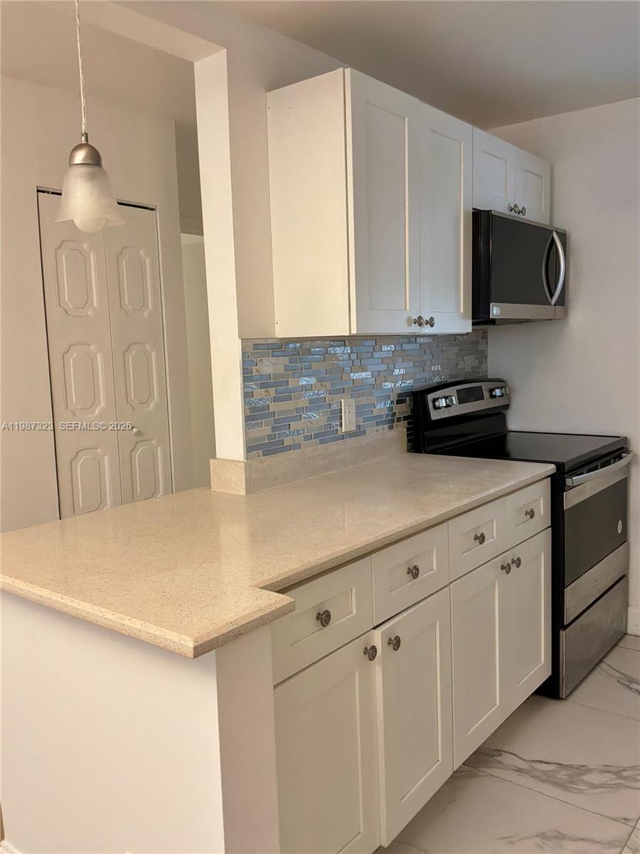 550 Southwest 2nd Avenue, Unit 1210 Boca Raton, FL 33432 - Photo 8 of 18 a kitchen with stainless steel appliances white cabinets and a sink