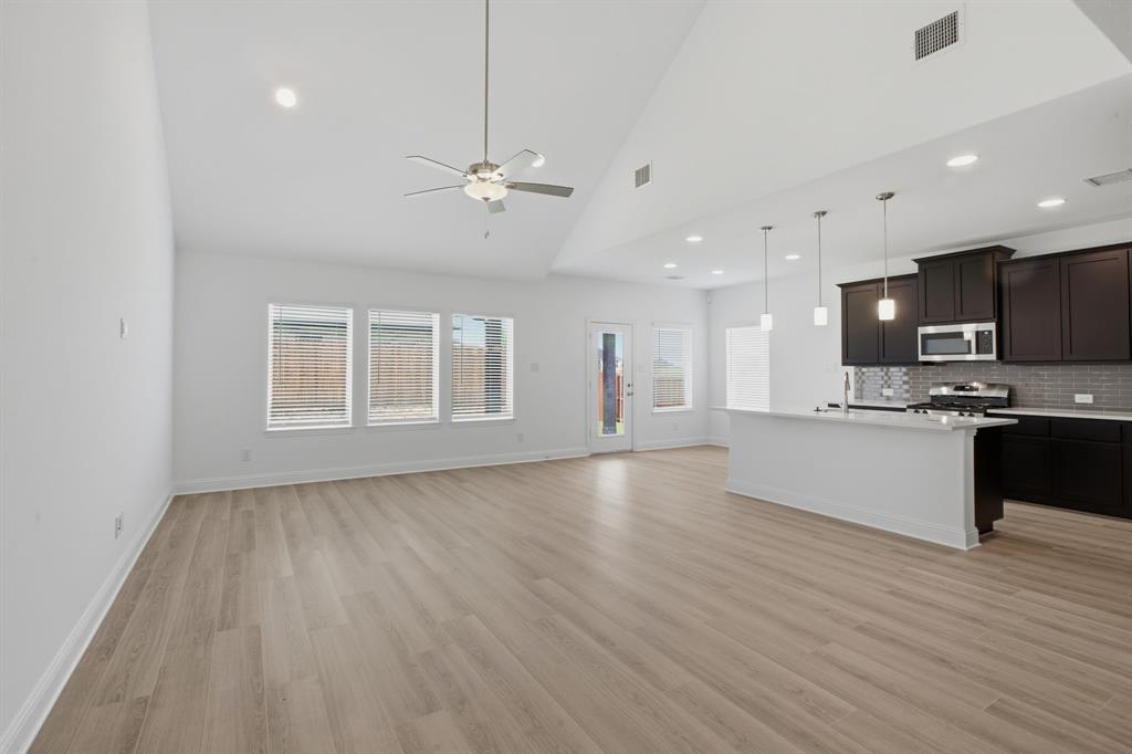 2911 Hanscom Street Forney, TX 75126 - Photo 20 of 40 Open-concept living space with vaulted ceilings and wood-finish flooring