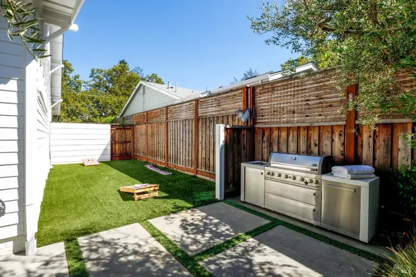 a view of a backyard with couches under an umbrella