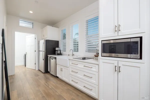 a kitchen with a refrigerator stove and white cabinets