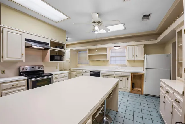 a kitchen with a stove a refrigerator and a stove top oven