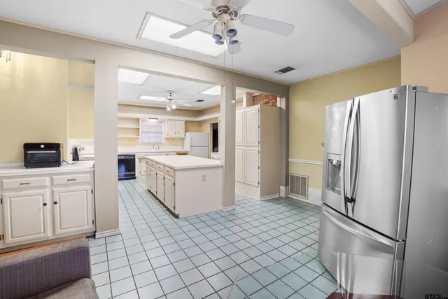 a kitchen with a refrigerator sink and cabinets