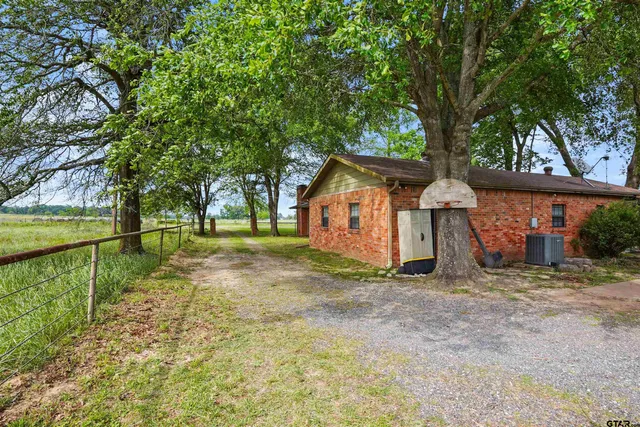 a view of a house with backyard and tree s