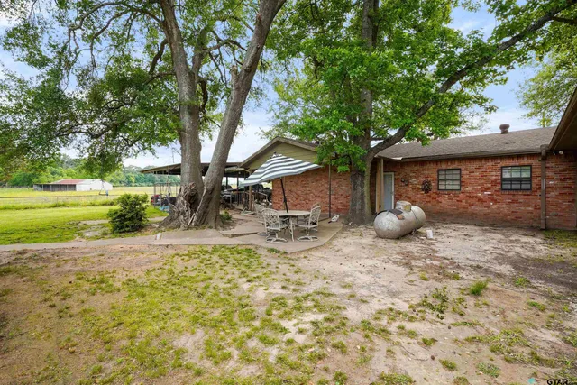 a backyard of a house with table and chairs
