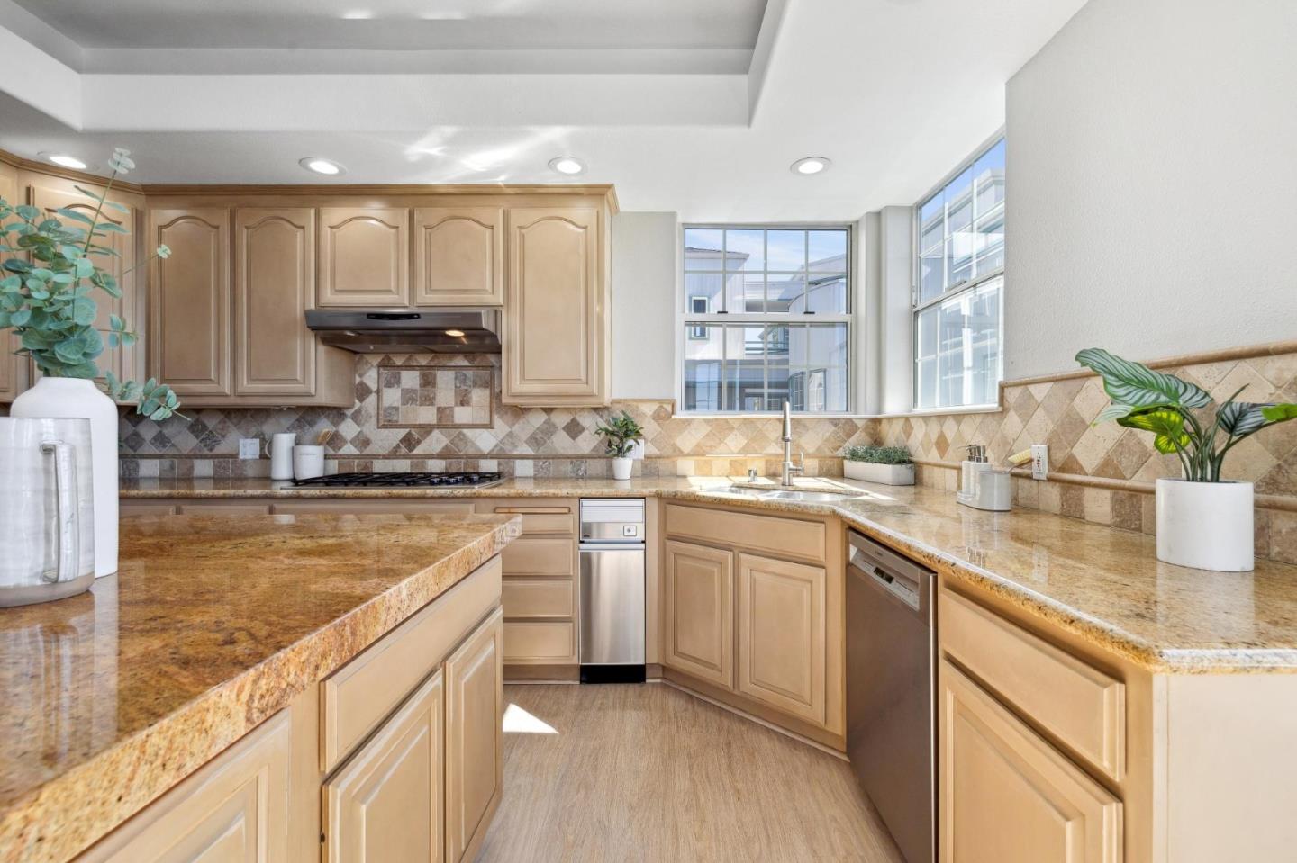 720 Promontory Point Lane, Unit 2305 Foster City, CA 94404 - Photo 43 of 78 a kitchen with kitchen island granite countertop a sink cabinets and window
