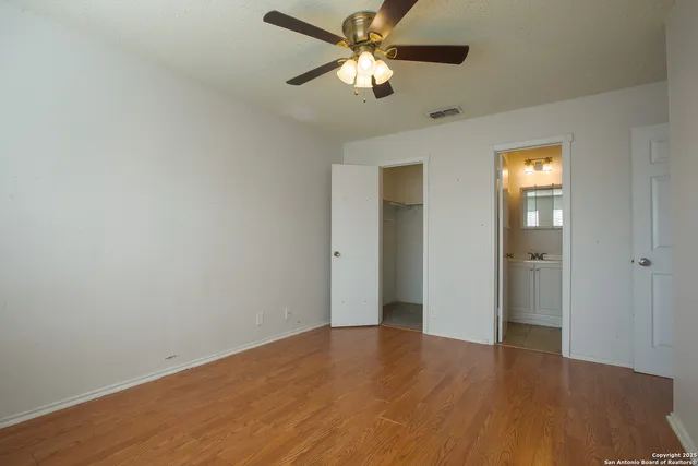 an empty room with closet and a ceiling fan