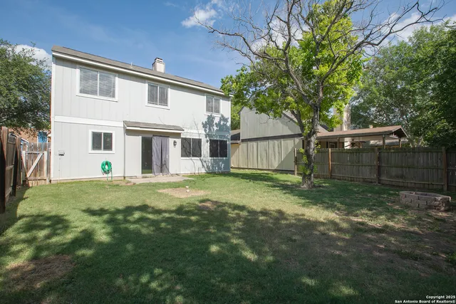 a view of a house with backyard and a tree