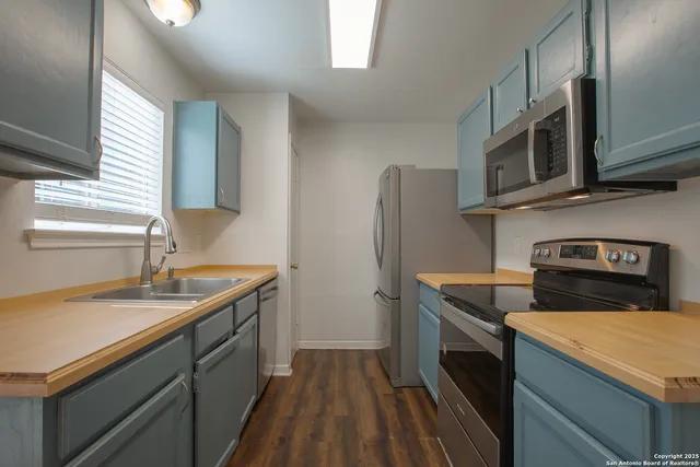 a kitchen with stainless steel appliances a stove microwave and refrigerator