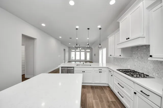 a view of an empty room with kitchen and kitchen view