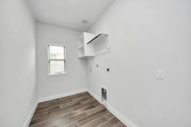 a kitchen with kitchen island a stove a sink a refrigerator and white cabinets with wooden floor