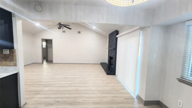 a view of a hallway with a white walls and a window