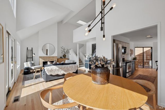 a living room with furniture a chandelier and wooden floor