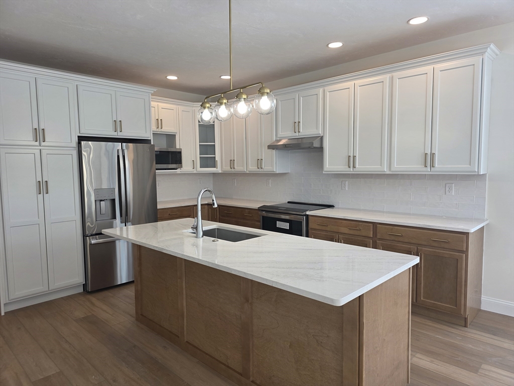 4 Fidelity Drive, Unit 2 Rutland, MA 01543 - Photo 12 of 14 a kitchen with stainless steel appliances granite countertop a refrigerator a sink dishwasher a stove and white cabinets