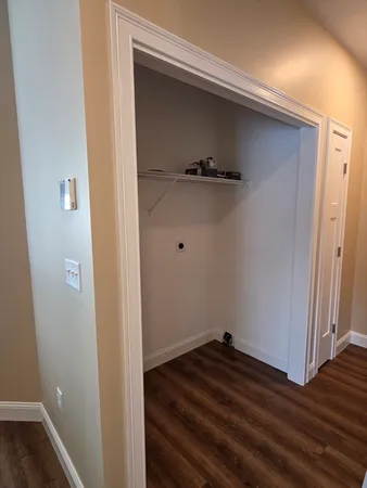 a view of a closet area with wooden floor