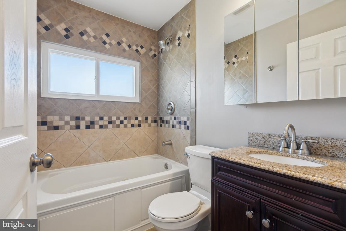 65 Gentle Road Levittown, PA 19057 - Photo 24 of 27 a bathroom with a granite countertop sink a toilet and bathtub