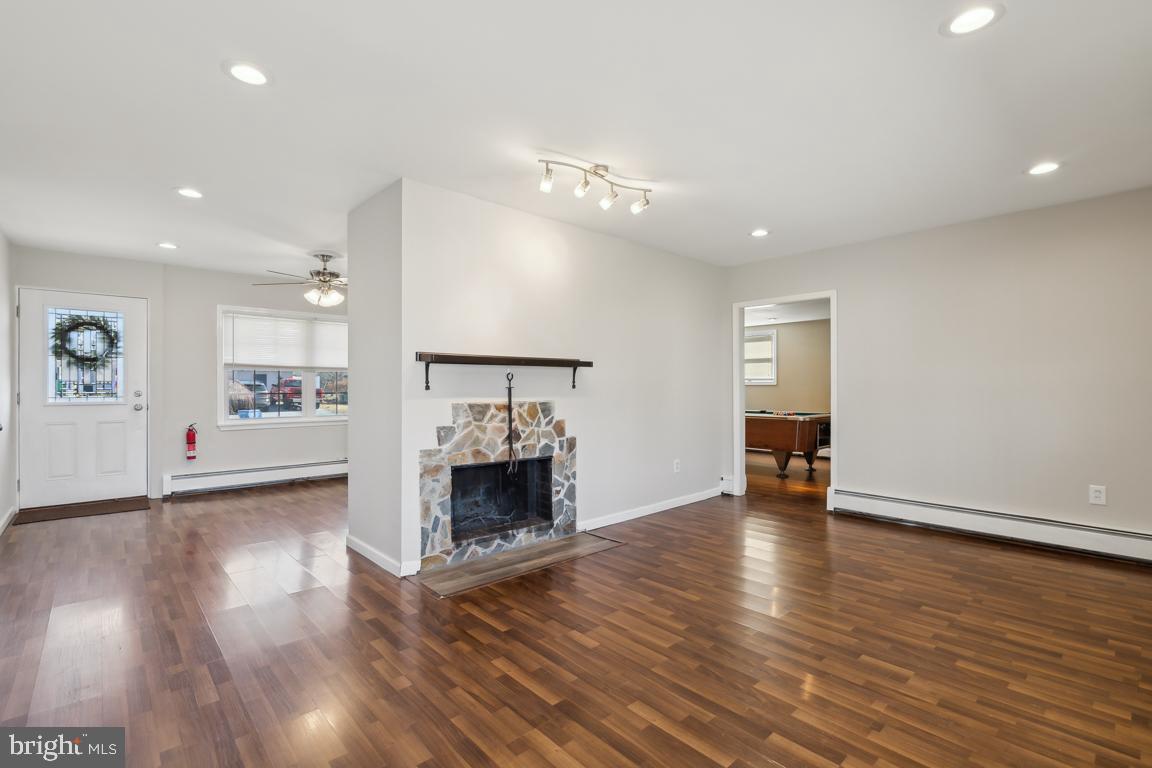 65 Gentle Road Levittown, PA 19057 - Photo 9 of 27 an empty room with wooden floor a fireplace and window