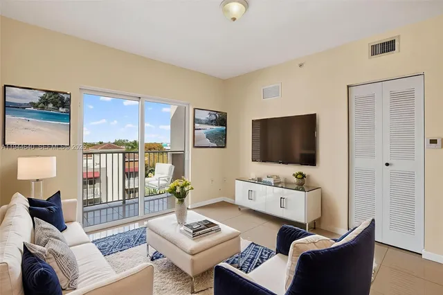 a living room with furniture a flat screen tv and a large window