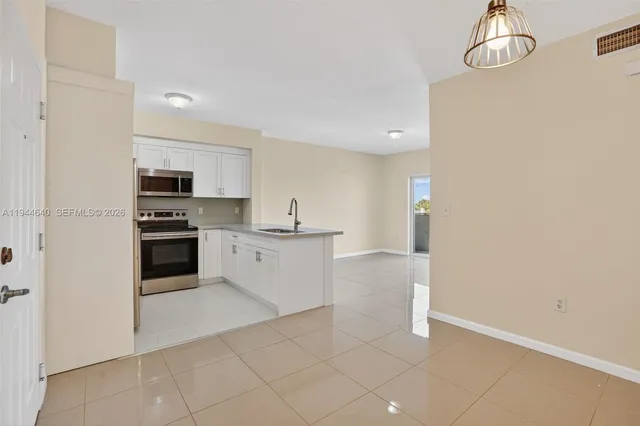 a kitchen with granite countertop a refrigerator and a stove top oven