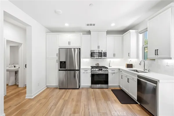 a kitchen with stainless steel appliances a sink stove and cabinets