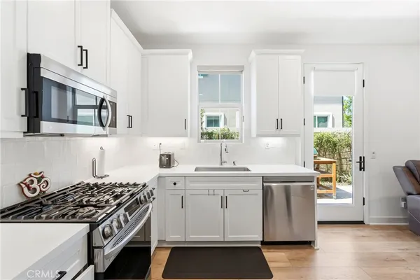 a kitchen with a refrigerator a stove a dining table and chairs
