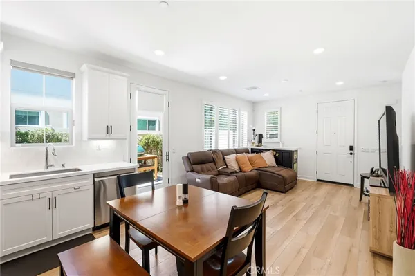 a living room with furniture kitchen view and a large window