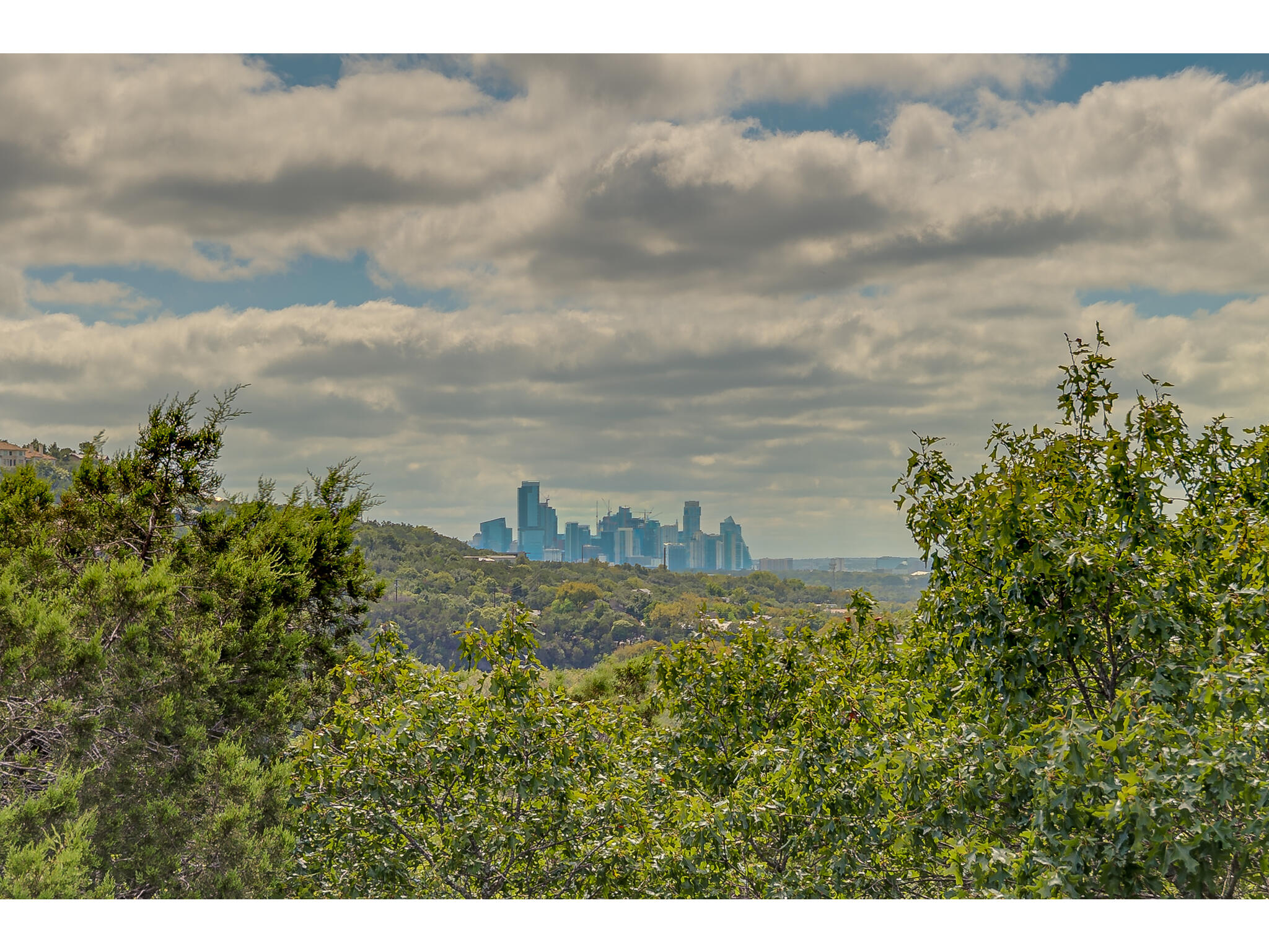 1602 Wild Basin Ledge Austin, TX 78746 - Photo 2 of 5 Elevated city skyline backdrop framed by expansive tree-filled terrain