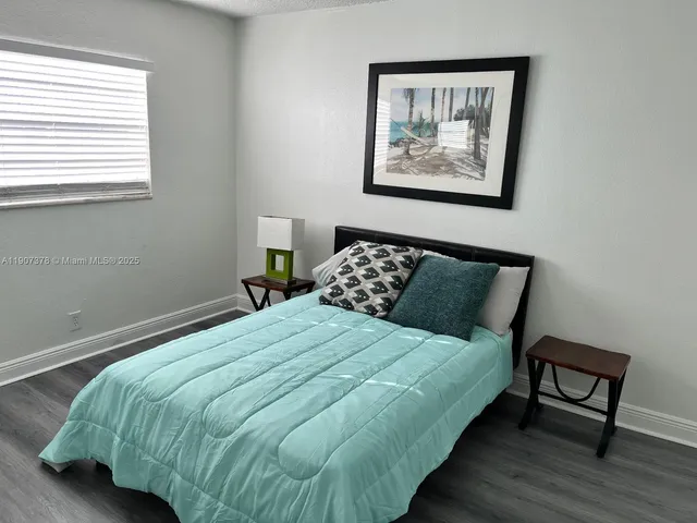 a large bed sitting in a bedroom next to a window