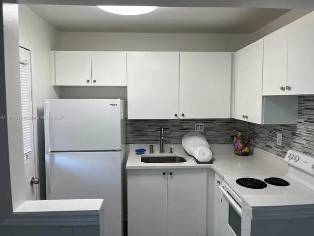 a kitchen with a stove and white cabinets