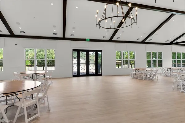 a dining room with furniture wooden floor a flat screen tv and a clock