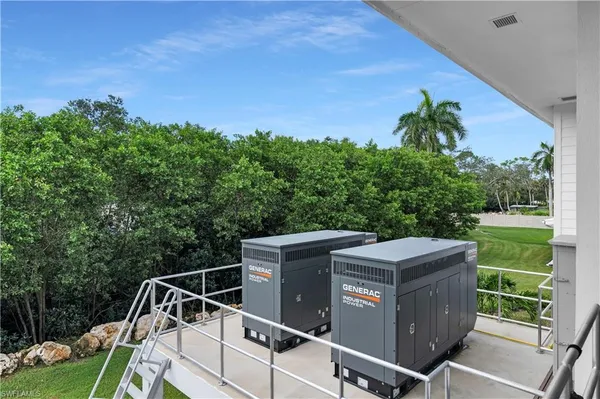 a view of a roof deck with couches and wooden fence