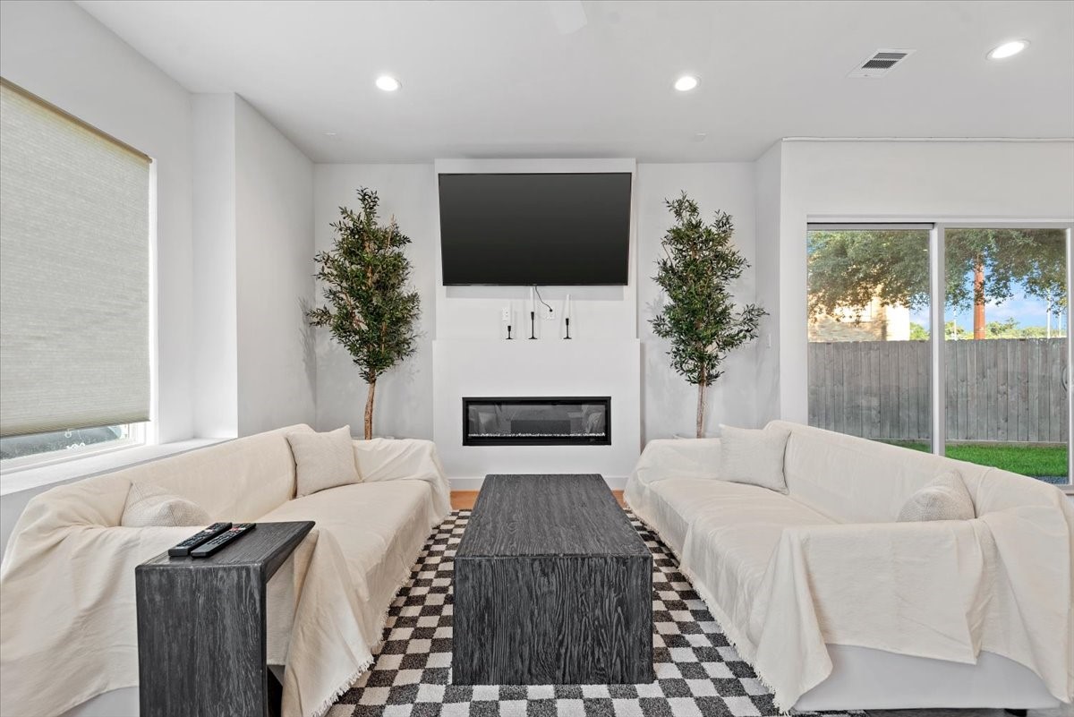 a living room with a couch a flat screen tv and a large window