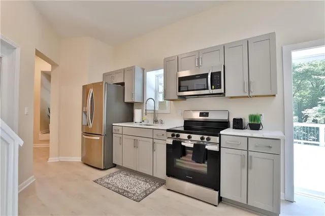 a kitchen with stainless steel appliances granite countertop a stove a refrigerator and a microwave