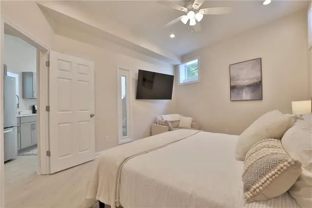 a bedroom with a bed window and a flat screen tv